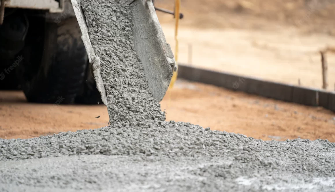 a-construction-worker-pouring-a-wet-concret-at-road-construction-site_33835-1156